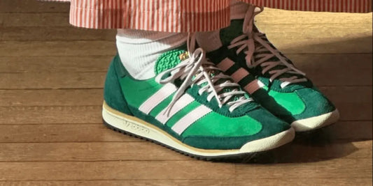 Une Adidas SL 72 verte portée avec un paire de chaussette blanche.