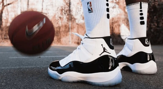 La Air Jordan 11 Concord portée avec des chaussettes Nike sur un terrain de basket-ball.