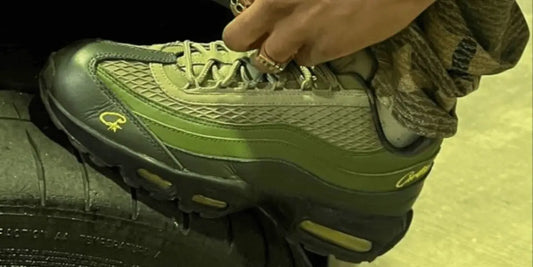 Une Nike Air Max 95 Corteiz portée avec un pantalon militaire.