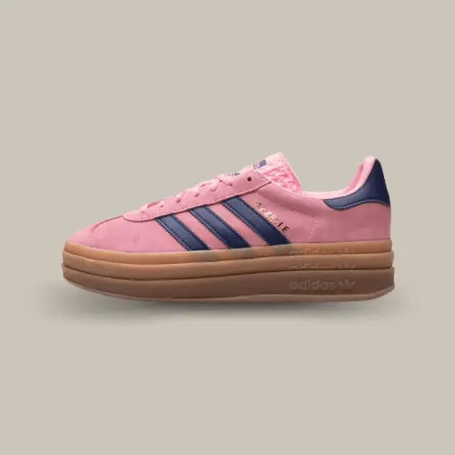 La Adidas Gazelle Bold Pink Glow de coté avec sa base en suède rose, ses trois bandes en cuir bleu marine accordé au talon et son épaisse semlle en gomme.