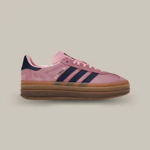 La Adidas Gazelle Bold Pink Glow de coté avec sa base en suède rose, ses trois bandes en cuir bleu marine accordé au talon et son épaisse semlle en gomme.