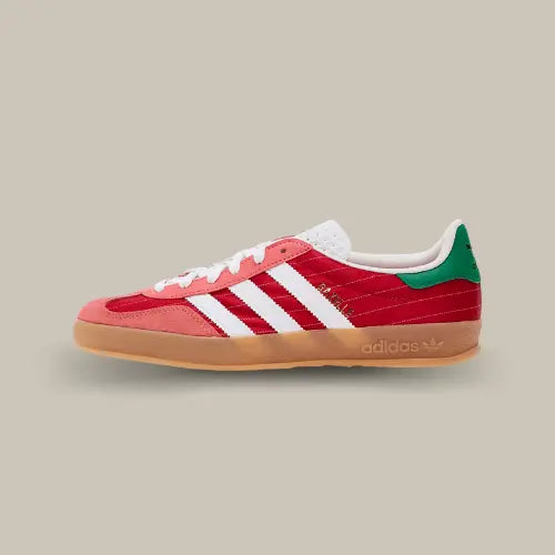 La Adidas Gazelle Indoor Better Scarlet "Olympic" vue de côté avec sa base en suède rouge à rayures blanches, ses trois bandes blanches et son heel tab vert.