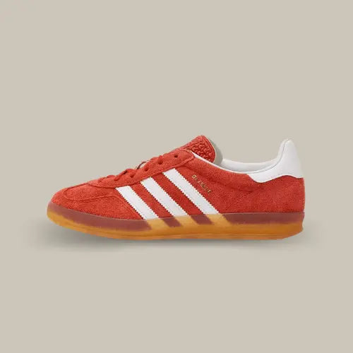 La Adidas Gazelle Indoor Bold Orange de coté avec sa tige en suède orange, ses trois bandes blanches et sa semelle en gomme de caoutchouc.