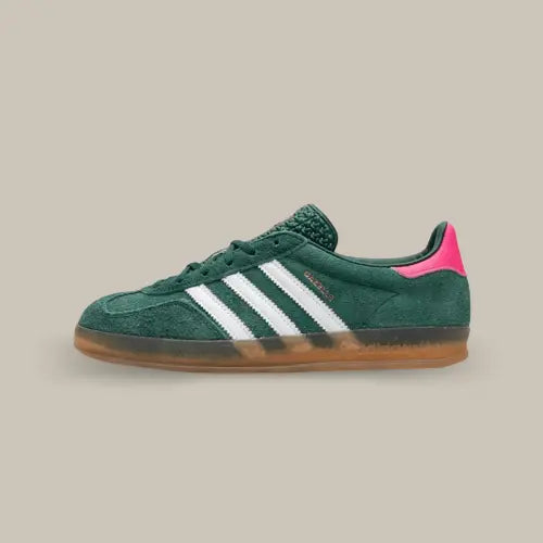 La Adidas Gazelle Indoor Collegiate Green Lucid Pink de coté avec sa base en suède vert sapin, ses trois bandes en cuir blanc, son talon rose et sa semelle en gomme transparente.