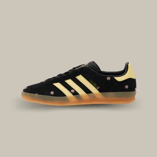 La Adidas Gazelle Indoor Core Black Almost Yellow Floral possède une base en daim noir avec ses trois bandes jaunes accordées au heel tab et ses petites fleurs parsemées sur toute la tige.