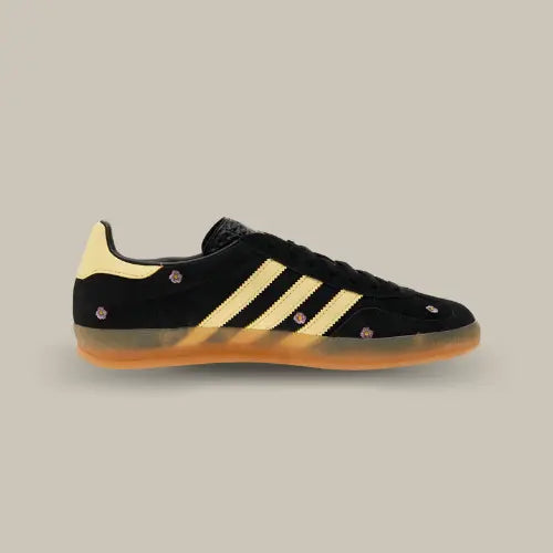 La Adidas Gazelle Indoor Core Black Almost Yellow Floral possède une base en daim noir avec ses trois bandes jaunes accordées au heel tab et ses petites fleurs parsemées sur toute la tige.