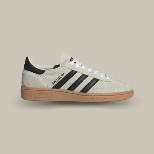 La Adidas Handball Spezial Aluminum Core Black vue de coté avec sa tige en nubuck gris, ses trois bandes en cuir noir et sa semelle en gomme.