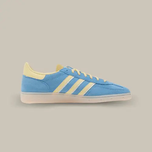 La Adidas Handball Spezial Semi Blue Burst Almost Yellow vue de côté avec son coloris bleu et ses trois bandes en cuir jaune accordées au heel tab et aux lacets.