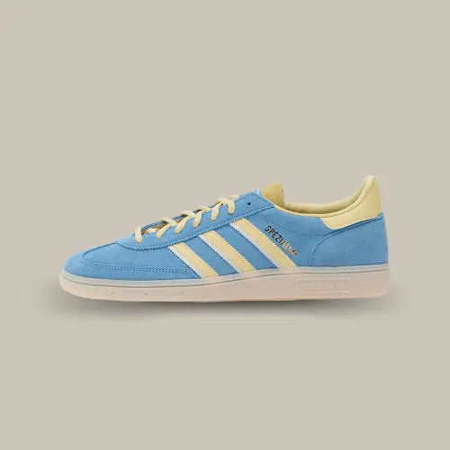 La Adidas Handball Spezial Semi Blue Burst Almost Yellow vue de côté avec son coloris bleu et ses trois bandes en cuir jaune accordées au heel tab et aux lacets.