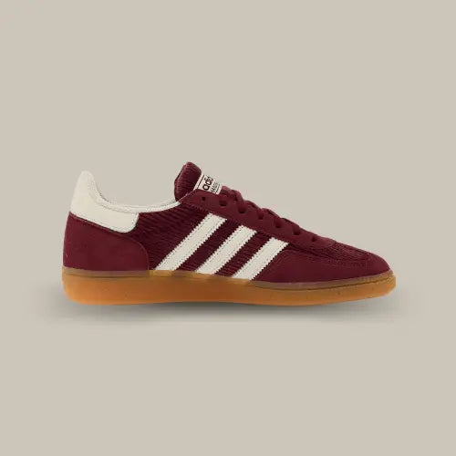 La Adidas Handball Spezial Shadow Red vue de côté avec sa base en suède bordeaux et ses trois bandes blanches accordées au heel tab.