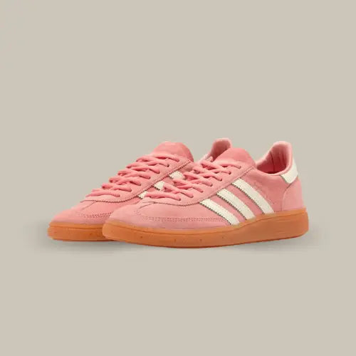 La Adidas Handball Spezial Sporty &amp; Rich Pink possède une base en daim rose avec les trois bandes blanches accordées au heel tab et au branding "Sporty&amp;Rich". La semelle en gomme de caoutchouc vient conclure cette splendide paire de basket tout en rose.