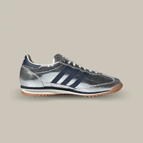 La Adidas SL 72 OG Silver Metallic Collegiate Navy avec sa base en cuir métallisé et ses trois bandes bleu nuit assorties au heel tab. On retrouve une semelle en gomme de caoutchouc beige.