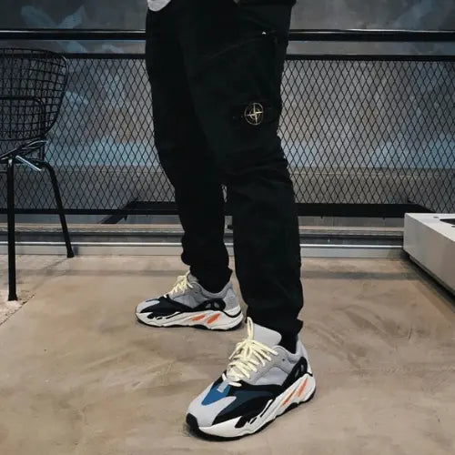 La Adidas Yeezy 700 Wave Runner Solid Grey portée avec un jogging noir.