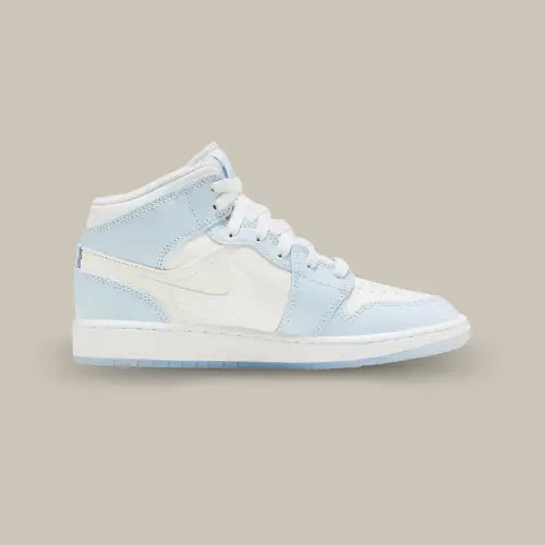 La Air Jordan 1 Mid Glitter Swoosh vue de côté avec sa base en cuir blanc, ses empiècements bleu clair et son swooch brillant à effet miroir.