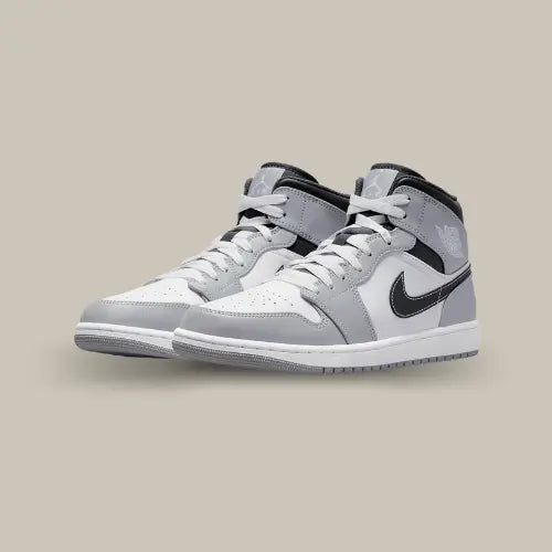 La Air Jordan 1 Mid Light Smoke Grey possède une base en cuir lisse de couleur blanche et grise. On retrouve un swoosh noir assorti au col qui vient contraster la paire pour un magnifique rendu.&nbsp;