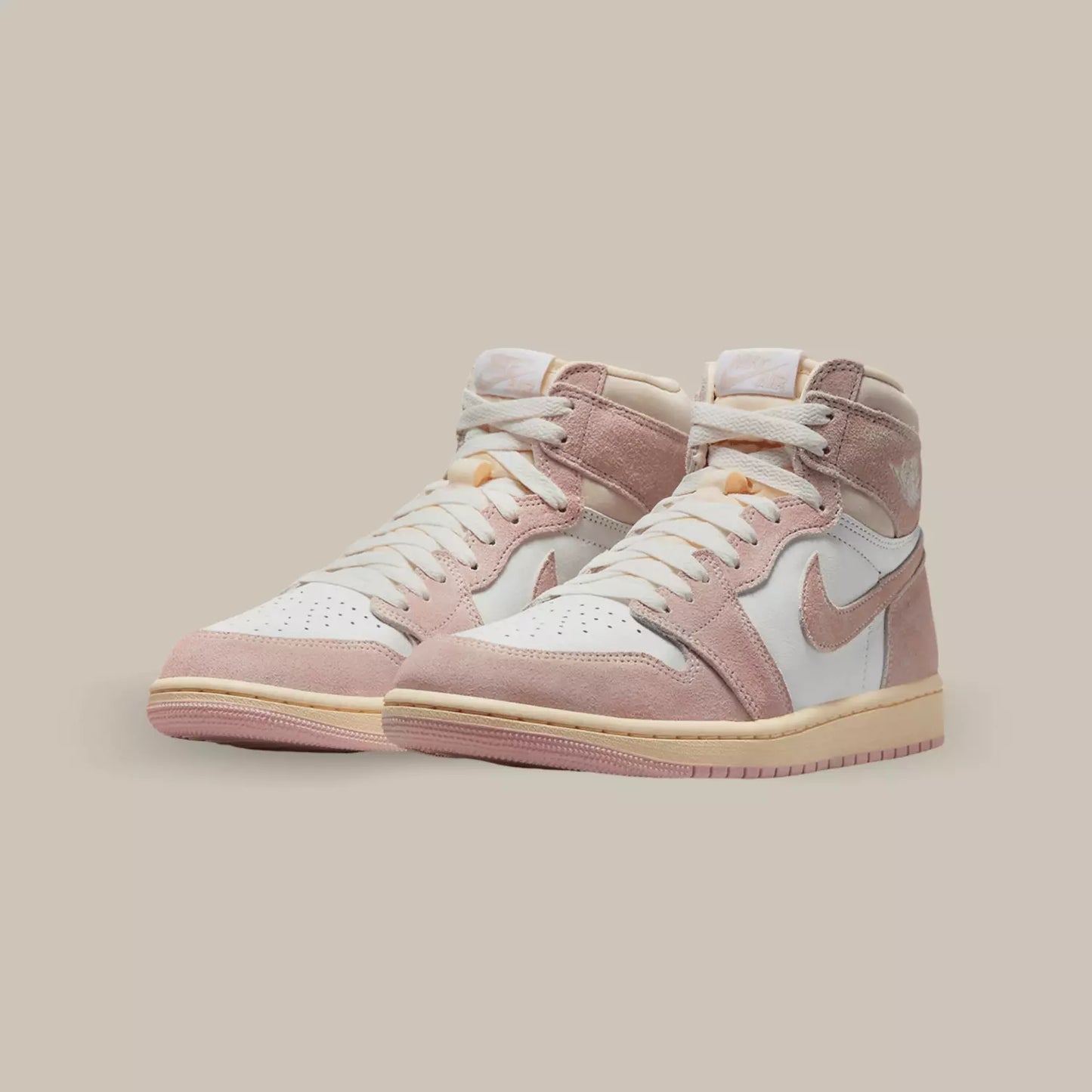 Cette Air Jordan 1 Retro High OG Washed Pink présente une base en cuir blanc, surmontée d’empiècements en daim rose pastel à l’aspect légèrement délavé.