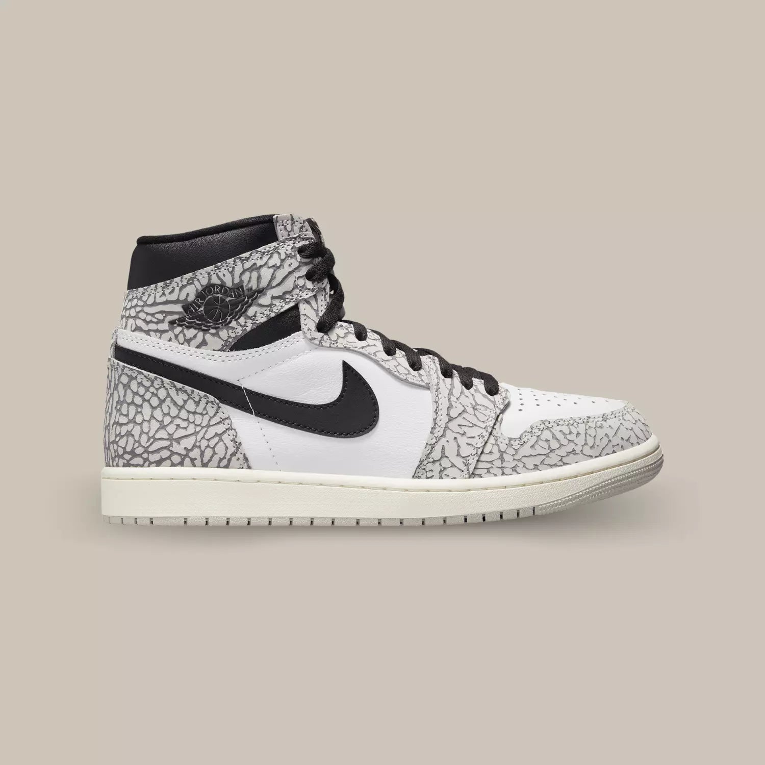 La Jordan 1 Retro High OG White Cement de coté avec une base en cuir blanc et des empiècements en cuir habillé du motif Elephant Print.