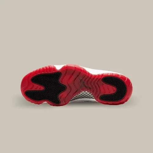 La semelle de la Air Jordan 11 Low White Bred de couleur rouge et noir.