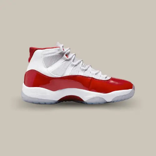 La Air Jordan 11 Retro Cherry (2022) vue de côté avec sa base en mesh blanc et son mudguard en cuir verni rouge cerise.