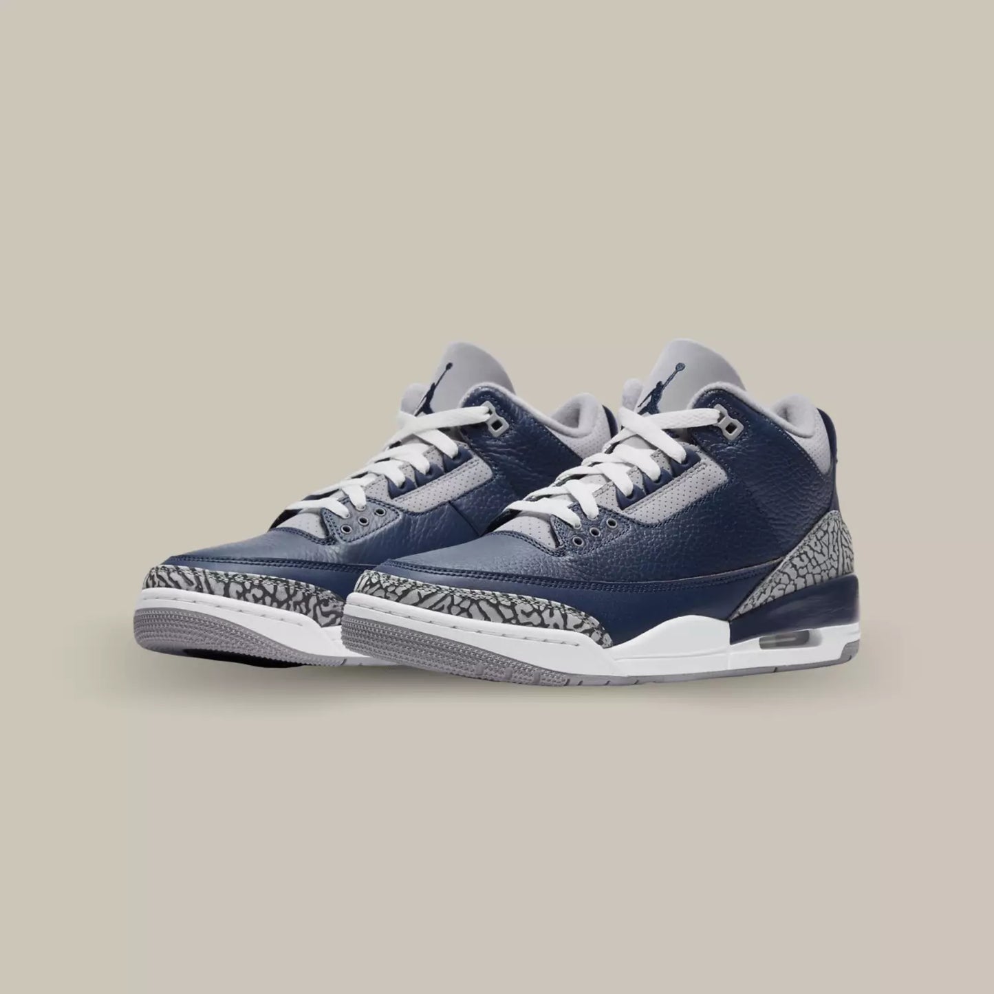 La Jordan 3 Retro Georgetown affiche une base en cuir grainé bleu marine avec des parties en suède affichant le motif Elephant Print. On retrouve une semelle blanche et grise pour rappeler le maillot exterieur de l’université de Georgetown.