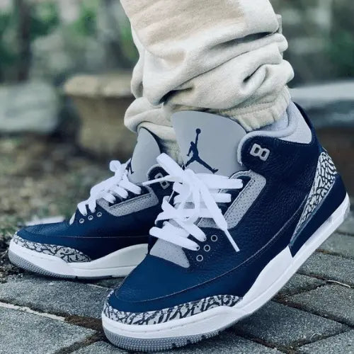 La Air Jordan 3 Georgetown portée avec un jogging gris.