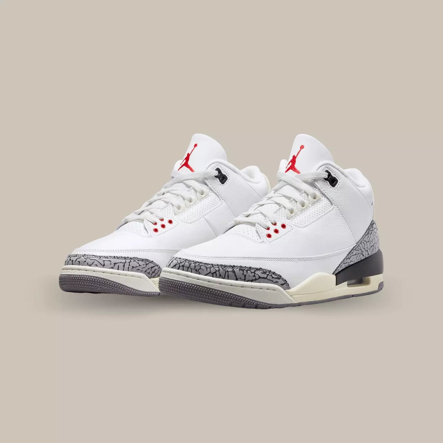 La Air Jordan 3 Retro White Cement Reimagined dévoile un upper en cuir grainé blanc. On distingue ensuite des empiècements en elephant print sur le mudguard et le renfort talon tandis que le branding Nike Air écru et noir s’accorde à la midsole pour donner un effet vieilli.