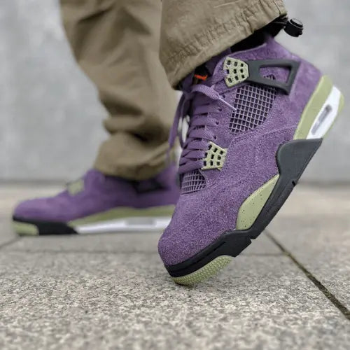 La Air Jordan 4 Canyon Purple portée avec pantalon cargo kaki.