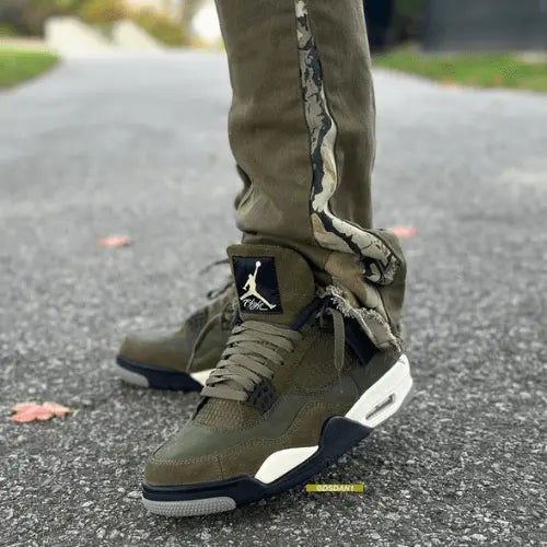 La Air Jordan 4 Retro SE Craft Medium Olive portée avec un pantalon vert kaki.