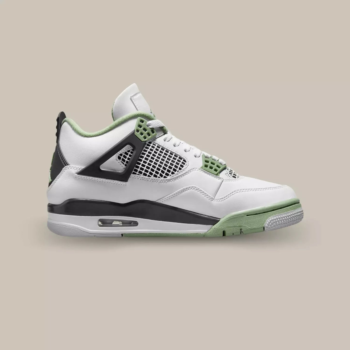 La Air Jordan 4 Seafoam de coté avec sa base en cuir blanc, son empiècement en mesh blanc et noir et ses œillets vert.