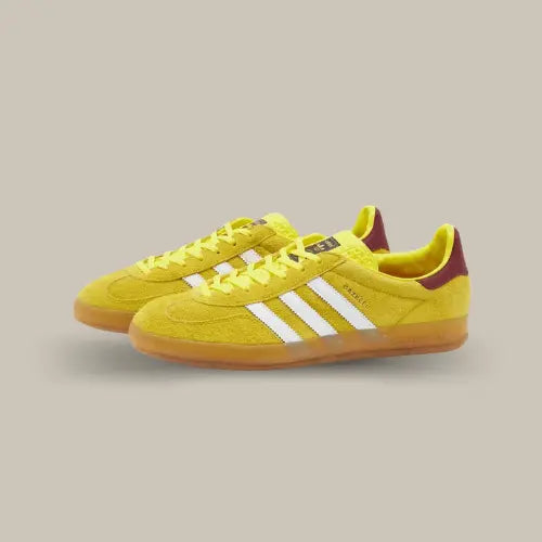 La adidas Gazelle Indoor Bright Yellow Burgundy possède une base en daim jaune accompagnée des trois bandes blanches. On retrouve un cuir bordeaux sur le talon et une semelle en gomme.