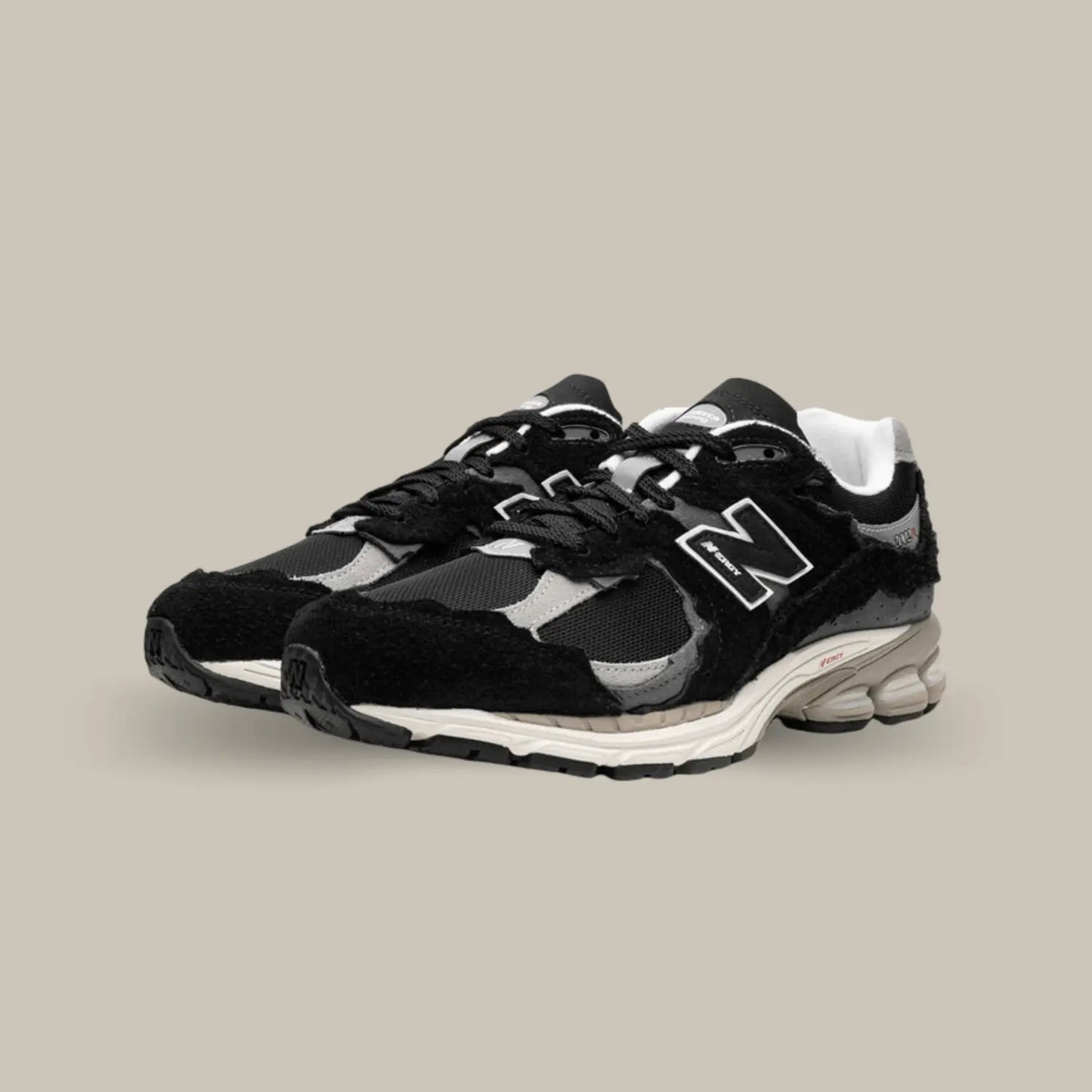 La New Balance 2002R Protection Pack Black dévoile une base en mesh noir accompagnée de superpositions en daim ton-sur-ton au look déchiré pour donner le fidèle aspect déconstruit.