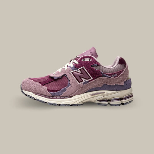 La New Balance 2002R Protection Pack Pink de coté avec une base qui associe mesh, cuir lisse et suède. Cette nouvelle version présente un design penchant vers des coloris rose.