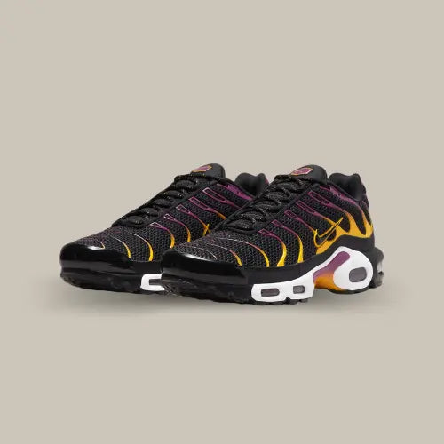 La Nike Air Max Plus Gradient Black présente une base en mesh noir avec des éléments en TPU possédant un dégradé allant du violet au orange. La semelle bicolore blanche et noire comprend le système Air Sole avec des bulles transparentes. On retrouve le dégradé de couleur au milieu de la semelle rappelant un coucher de soleil à la paire.