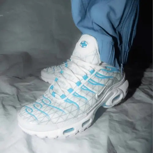 La Nike Air Max Plus Marseille portée avec un jogging bleu.