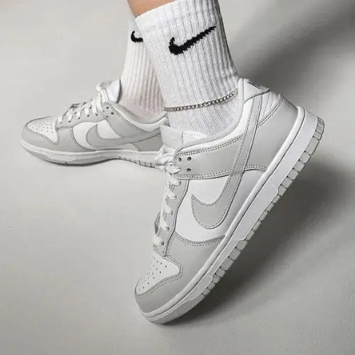 La Nike Dunk Low Grey Fog portée avec une paire de chaussette Nike blanche.