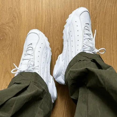 La Nike Hot Step Terra NOCTA White portée avec un pantalon cargo marron.