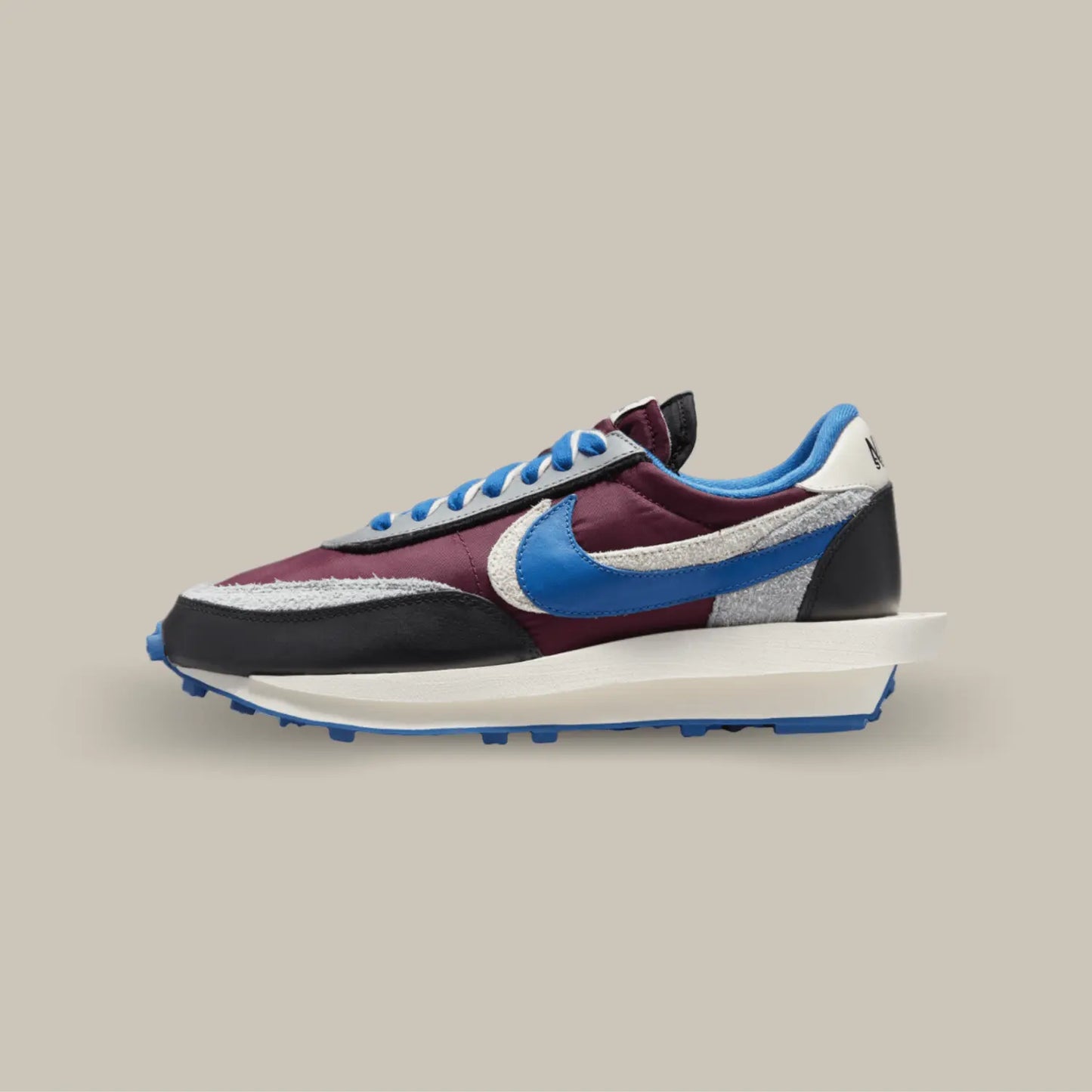 La Nike LD Waffle Sacai Undercover Night Maroon Team Royal de coté avec ses couleurs bleu et bordeaux avec quelques touches de noir, blanc et gris. On retrouve deux swoosh superposé de couleur bleu et blanc.