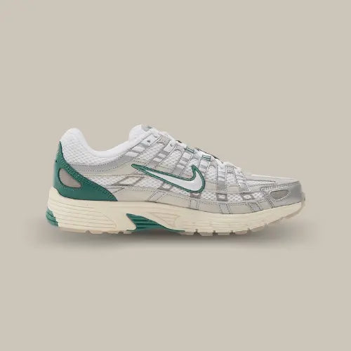 La Nike P-6000 Light Bone vue de côté avec son coloris blanc et ses empiècements en cuir argenté. Des touches de vert agrémentent la chaussure autour du swoosh et au niveau du renfort du talon.