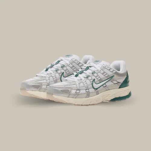 La Nike P-6000 Light Bone possède une base en mesh blanc avec des empiècements en cuir couleur métallisé. Des touches de vert viennent apporter du contraste à la paire au niveau du talon et autour du swoosh.