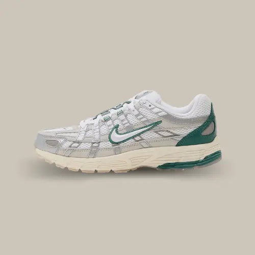 La Nike P-6000 Light Bone vue de côté avec son coloris blanc et ses empiècements en cuir argenté. Des touches de vert agrémentent la chaussure autour du swoosh et au niveau du renfort du talon.