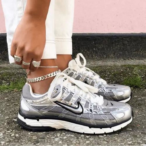 La Nike P-6000 Metallic Silver portée avec un pantalon court blanc et un bracelet de cheville.