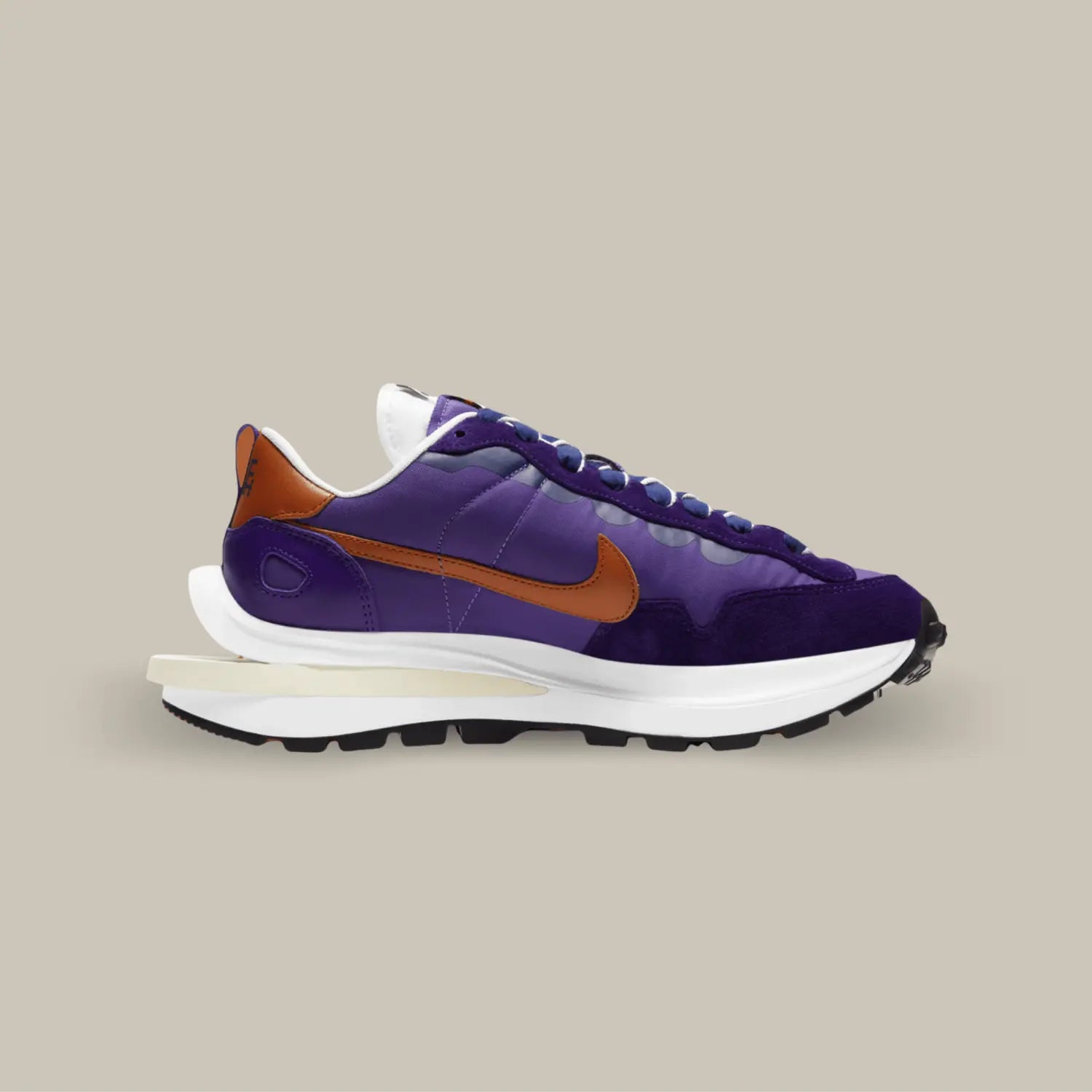 La Nike Vaporwaffle Sacai Dark Iris de coté avec sa couleur composé de nuances violettes et de nuance de bleu nuit. On retrouve un swoosh marron.