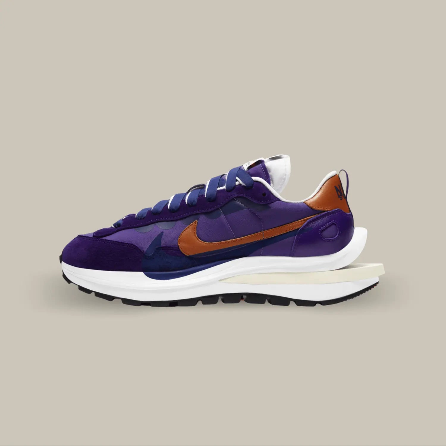 La Nike Vaporwaffle Sacai Dark Iris de coté avec sa couleur composé de nuances violettes et de nuance de bleu nuit. On retrouve un swoosh marron superposé d'un swoosh bleu nuit.